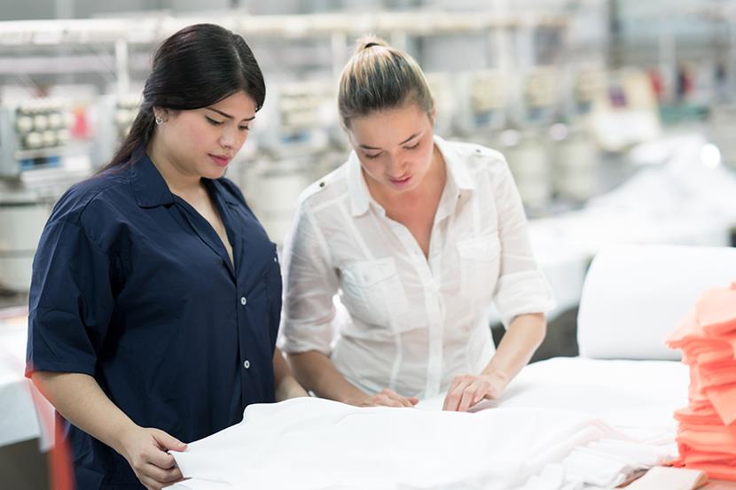 two women examining clothing in the textile manufacturing industry