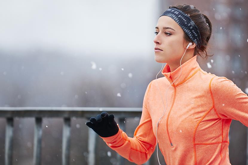 woman wearing jacket gloves hat jogging in winter weather