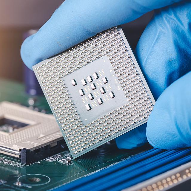 technician laying a cpu on the socket of a computer motherboard