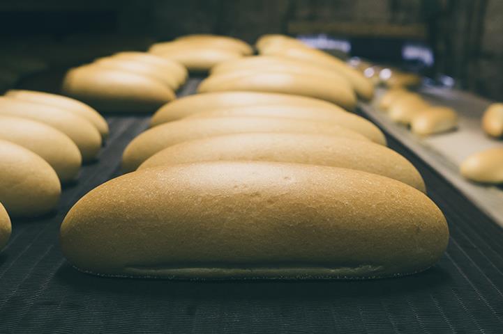 golden loaves of freshly baked bread on commercial baking sheets