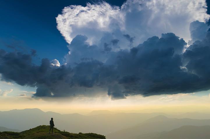 Person standing on a mountain under a blue sky